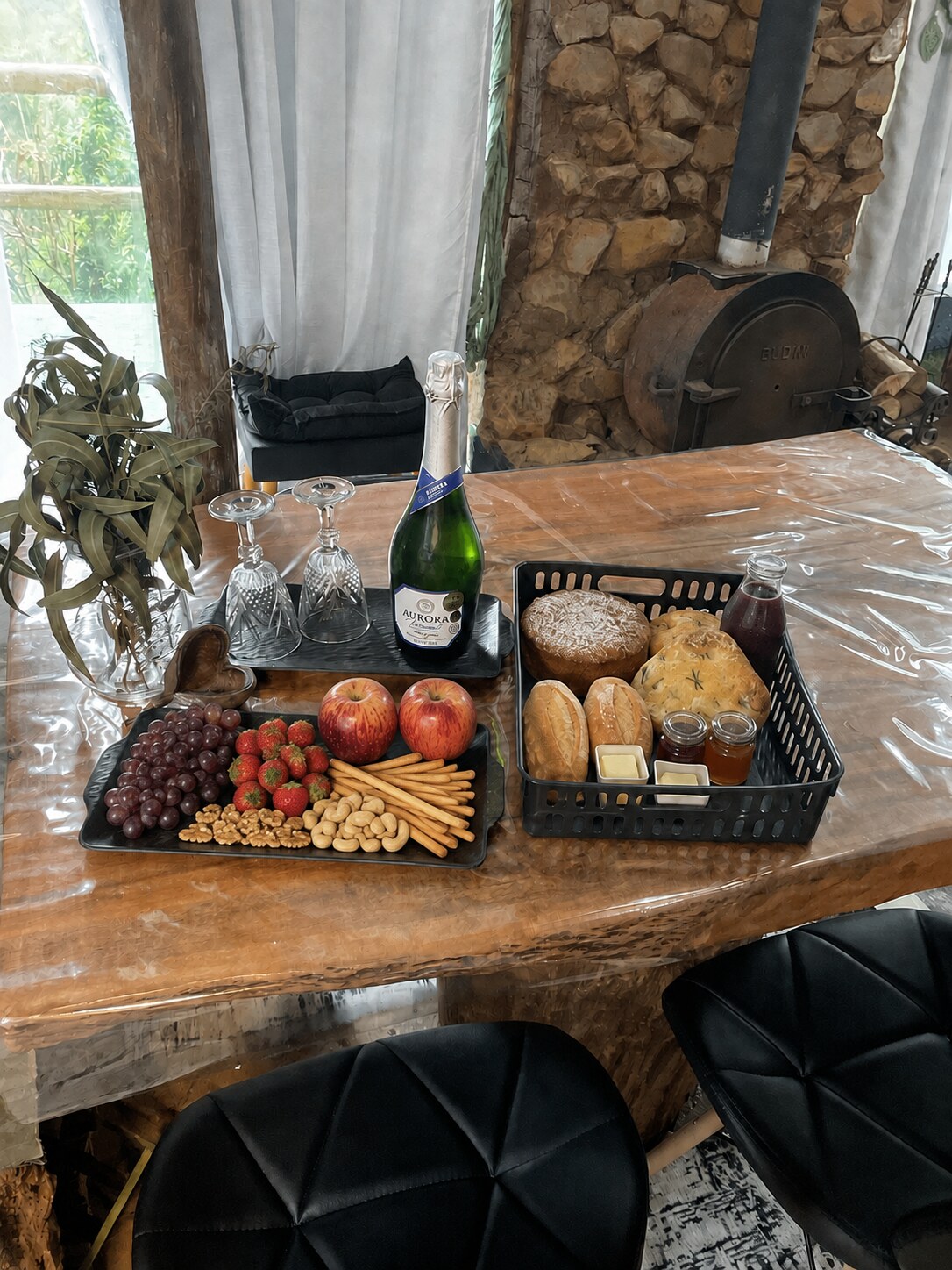 Espumante, uvas, morangos e cesta com pães e suco para uma experiência no Refúgio Nárnia